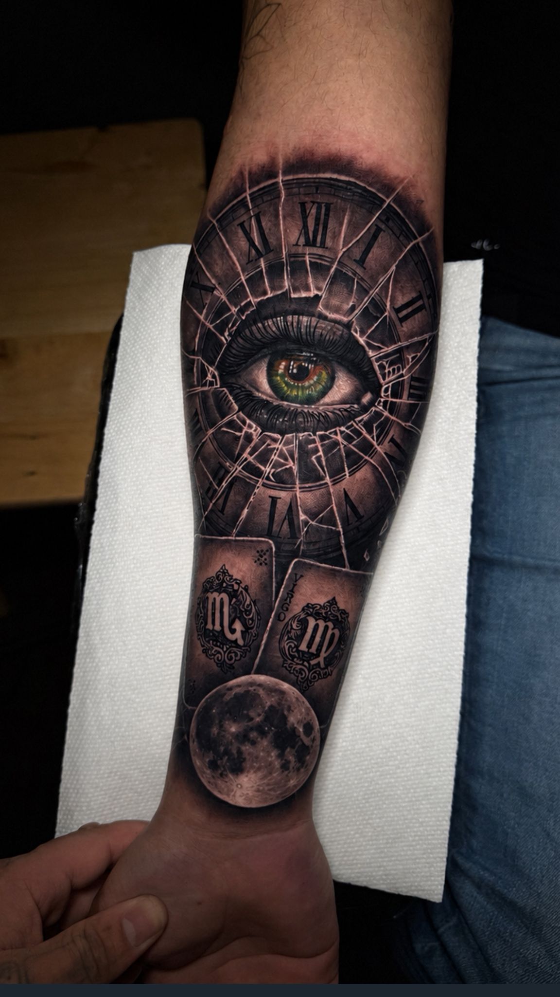 Black and grey eye and clock tattoo on an arm by Jonathan Cataño